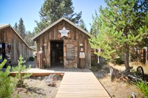 森赖弗Bend-Sunriver Camping Resort 24 ft. Yurt 16的一座木质建筑,前面有标志