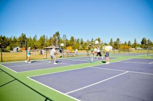 森赖弗Bend-Sunriver Camping Resort 24 ft. Yurt 16的一群人在网球场打网球