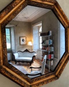 坎佩尔托尼奥Villa Ottocento的镜子反射着一个配有沙发和椅子的房间