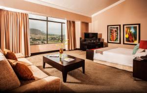 马塞卢Avani Lesotho Hotel & Casino的酒店客房配有床、沙发和桌子。