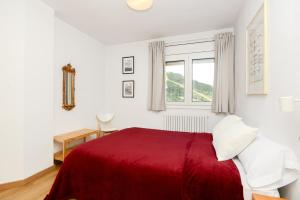 索尔德乌Apartamento Fontargent的白色的卧室设有红色的床和窗户