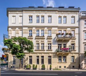 克拉科夫Gem Apartment by Castle (Old Town Krakow)的一座白色的大建筑,上面有花盒