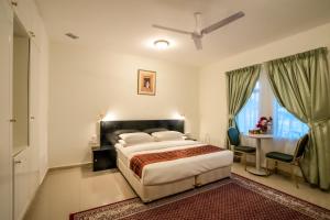 马斯喀特Hotel Summersands Al Wadi Al kabir的一间卧室配有一张床、一张桌子和一个窗户。