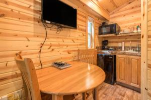 韦尔奇蒙特胡德村5号豪华度假屋的一间带木桌和电视的用餐室