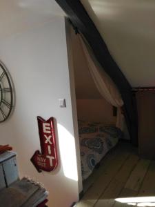 Les AgeuxLe Grenier的一间小房间,阁楼上配有一张床