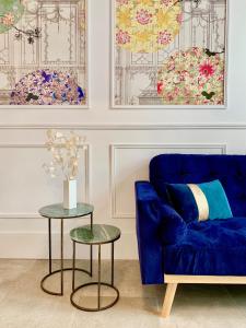 蒙彼利埃Home Chic Home - Les Suites de La Comédie的客厅配有蓝色的沙发和2张桌子