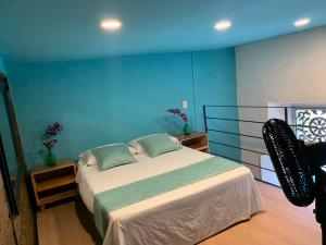 卡利Moonshine Boutique Hostal的一间卧室设有一张床和蓝色的墙壁