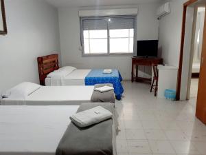 阿雷格里港Pousada Terra Sul的酒店客房设有两张床和电视。