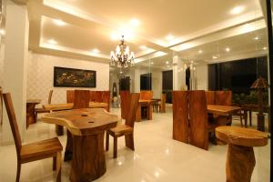 罗威那瓦育达那旅馆的用餐室配有木桌和椅子