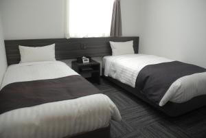 东京Okachimachi Urban Hotel的酒店客房设有两张床和窗户。