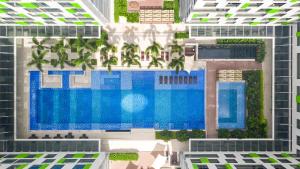 胡志明市Holiday Inn & Suites Saigon Airport, an IHG Hotel的享有带游泳池的建筑的空中景致