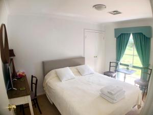 梅尔顿Melbourne Garden Bed and Breakfast的卧室配有白色的床和窗户。