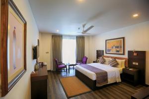 贾夫纳Fox Jaffna的酒店客房带一张床、一张桌子和椅子