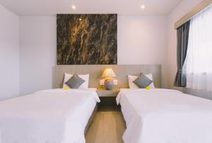 卡塔海滩幻想山简易别墅酒店的墙上画画的房间里设有两张床
