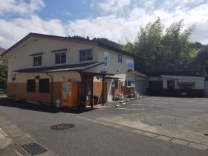 高千穗町Guest House Shizuho的前面有停车位的大楼