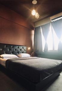 古晋Borneo Sweet Guesthouse的一间卧室设有一张床和一个窗口