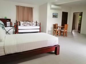 波尔多·格尼拉Nirvana Resort Puerto Galera的卧室配有一张床和一张桌子及椅子