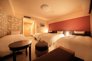 那霸里士满那霸久茂地酒店的酒店客房设有三张床和一张桌子