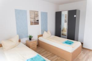 菲尔特Central Apartments Nürnberg-Fürth的小型客房的两张床,配有镜子