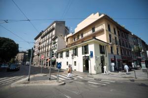 米兰Be Mate Via Tivoli的一条街道与白色建筑的交汇处