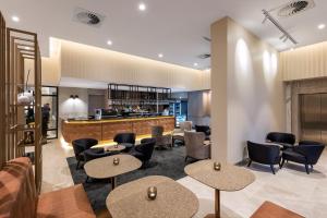 堪培拉Deco Hotel Canberra的大堂设有桌椅和酒吧。