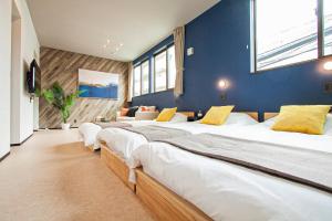 札幌UCHI Living stay NAKAJIMA park的蓝色墙壁的房间的一排床位