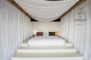 达赫拉La Crique Nature & Spa的卧室配有白色的白色床和白色的窗帘