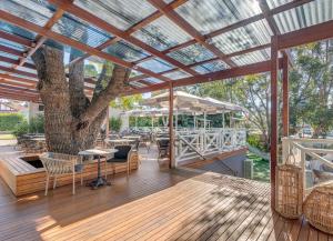 悉尼Wentworth Hotel的庭院里种着树,配有桌椅
