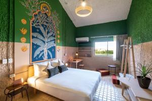 坎昆Selina Cancun Laguna Hotel Zone的一间卧室设有一张床和绿色的墙壁