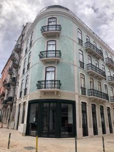 里斯本Be Lisbon Hostel Intendente的蓝色的建筑,旁边设有阳台