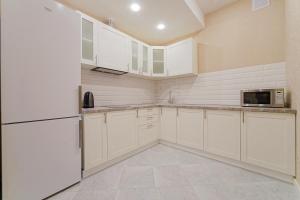 明斯克Apartments on Krasnaya Street的厨房配有白色橱柜和微波炉