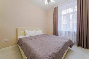 明斯克Apartments on Krasnaya Street的一间卧室设有一张床和一个大窗户