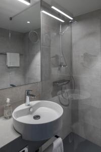 山麓布伦Hotel Rainers21的浴室配有白色水槽和淋浴。