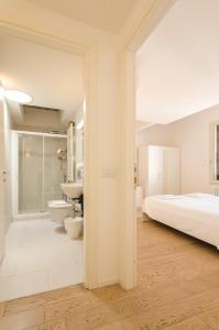 博洛尼亚Appartamento del Nettuno的一间卧室设有一张床和一间浴室。