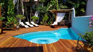 伊塔卡雷布伦丹家旅馆的一个带椅子的木制甲板上的游泳池和一个庭院