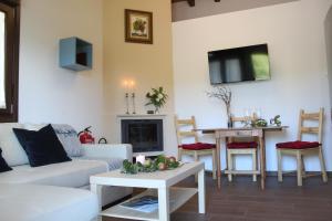OviñanaLas Carriles Apartamentos rurales的客厅配有白色沙发和电视