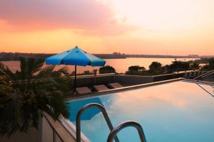 开罗Holiday Inn Cairo Maadi, an IHG Hotel的一个带遮阳伞的游泳池,享有水景