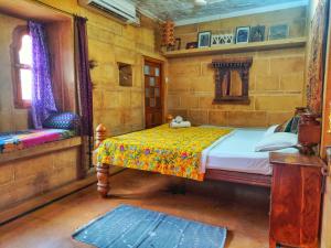 斋沙默尔Shahi Palace Hotel Jaisalmer的一间卧室配有一张床和一把椅子