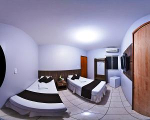MaracanaúPousada das Maracanãs的酒店客房设有两张床和电视。