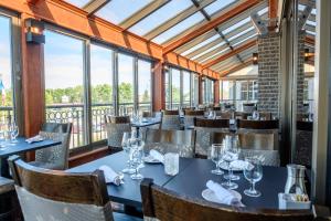 萨格奈勒蒙塔格奈酒店的用餐室设有桌椅和窗户。