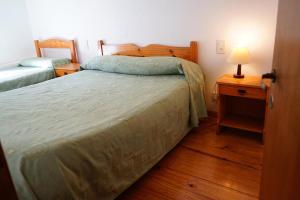 卡尔韦Apart Flavia的一间卧室配有一张床和一个带灯的床头柜