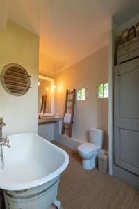 阿维尼翁茵特拉穆洛斯花园希谢度假屋的浴室配有白色浴缸和卫生间。