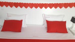 普赖尼亚德拜舒Barrocas do Mar的一张带两个红色枕头的白色床