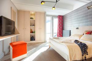 福勒恩Hôtel Club mmv Le Flaine ***的一间卧室配有一张床和一台电视。