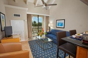 基督教堂市迪维南风海滩度假酒店的客厅配有蓝色的沙发和桌子