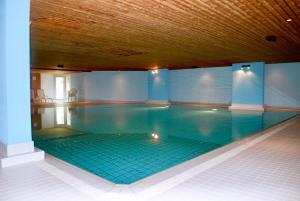 圣莫里茨CENTRAL PENTHOUSE GREAT LAKE VIEW的大型游泳池设有瓷砖地板和木制天花板