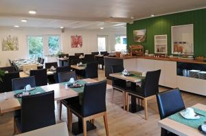 索尔陶Hotel Dat greune Eck的用餐室设有桌椅和绿色的墙壁