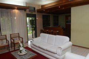 乌鲁瓜亚纳River Hotel的客厅配有白色的沙发和桌子