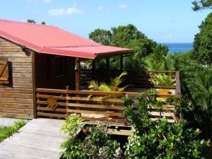 德赛Kaz Luciole的小屋设有红色屋顶和种有植物的门廊