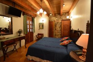 危地马拉安地瓜安地瓜坎德拉里亚酒店的一间卧室配有一张床、一张书桌和一面镜子